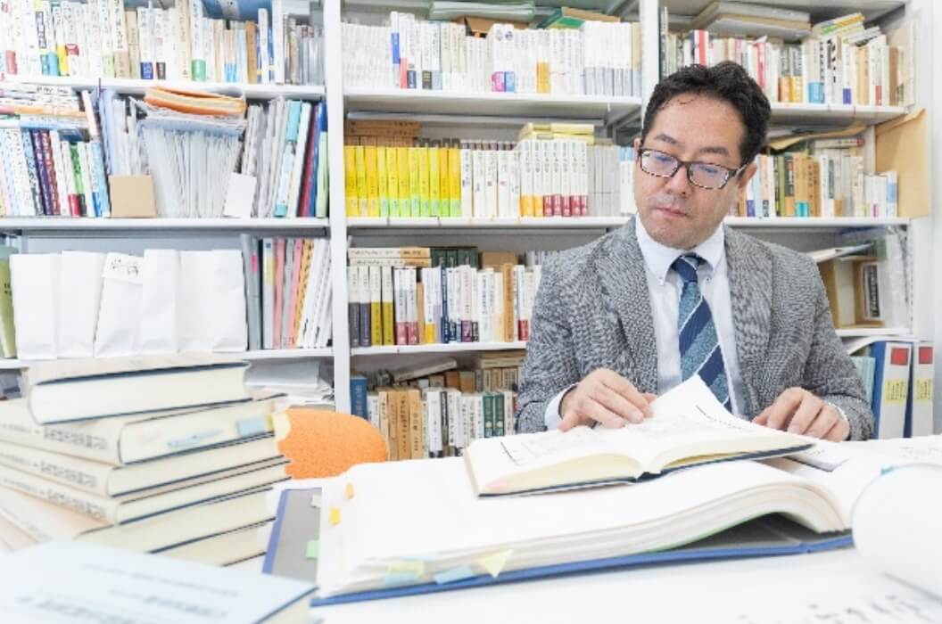 小山俊樹教授が史料を読んでいる様子