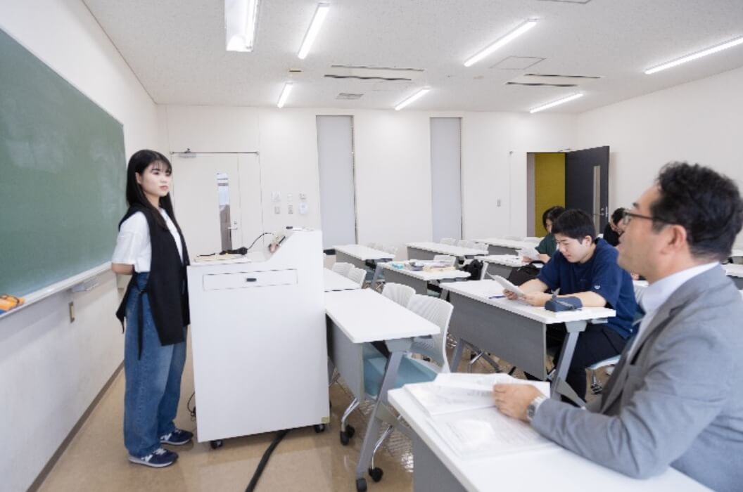 女性生徒が卒業論文の進捗報告会を行なう様子